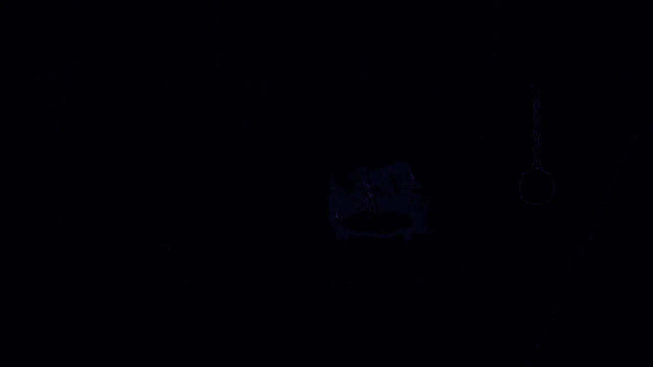 A nearly black image: faint outlines of the pot, chain, ball and rock edge